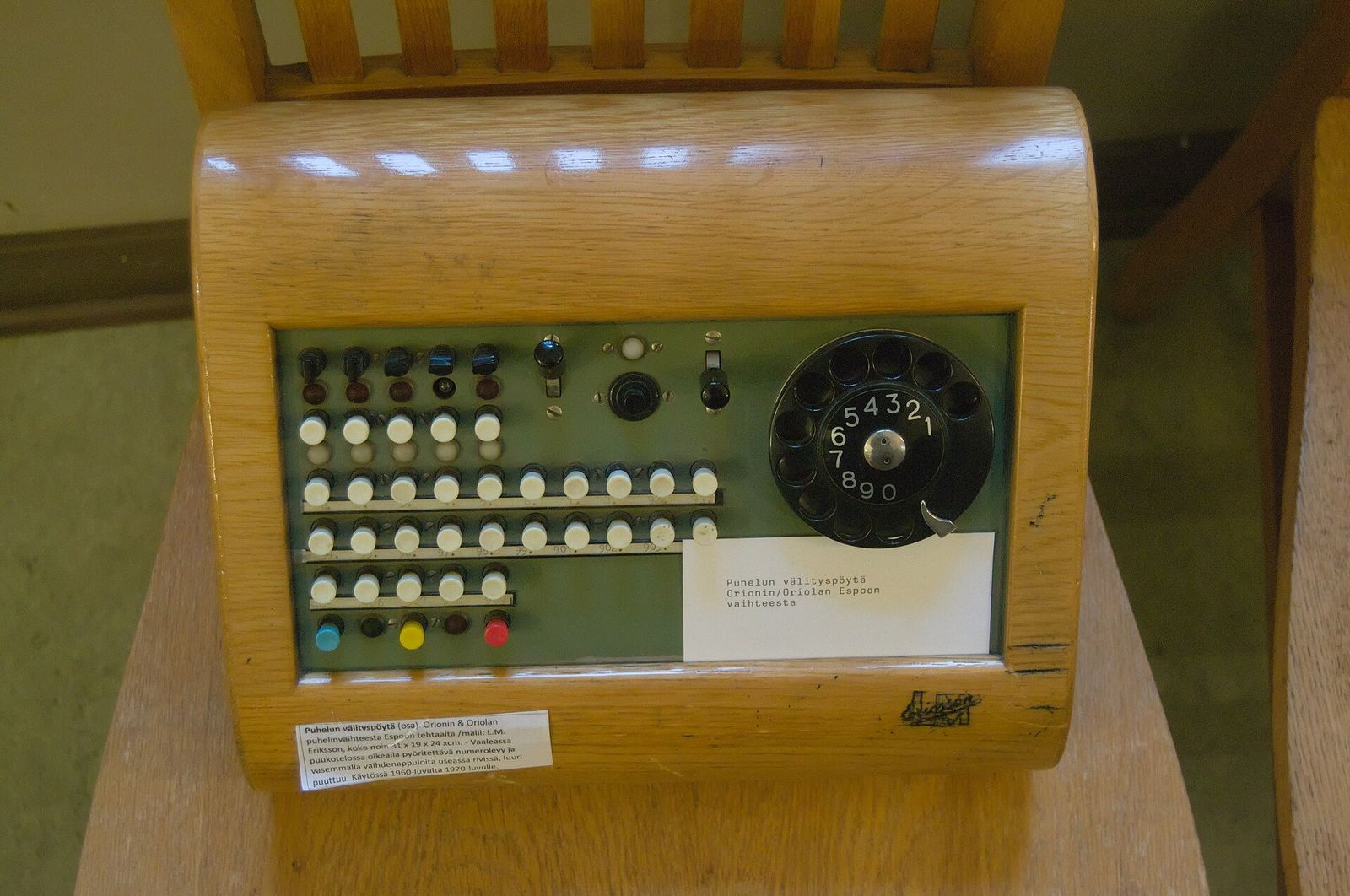 A manual telephone switchboard: rows of jacks and patch cords in a wooden frame.