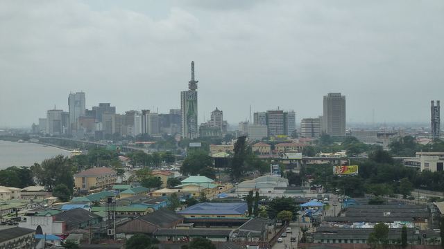 A Victoria Island street in Lagos: mid-rise buildings, parked cars, overhead cables.